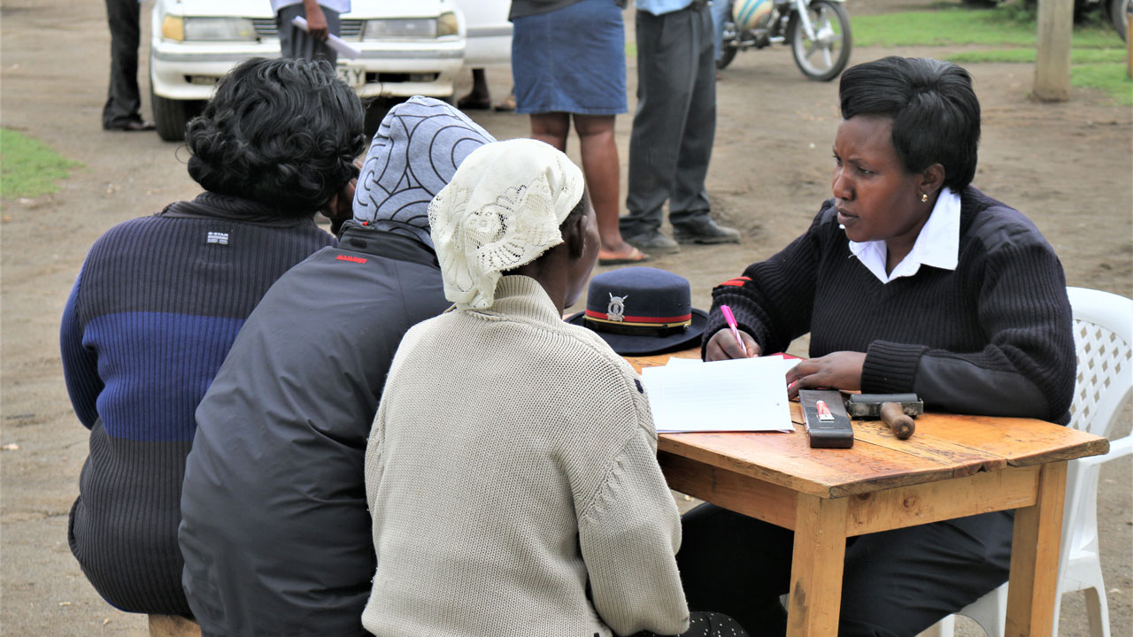 Recruiter at an outdoor event table interviewing three women