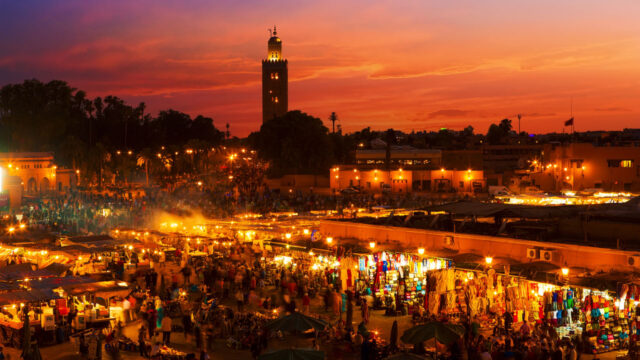 Angled aerial view of a marketplace on the outskirts of a Mediterranean city at sunset