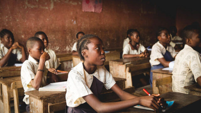 Schoolchildren sitting at wooden desks