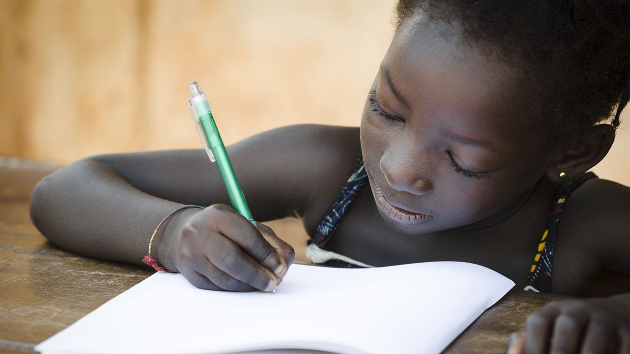 School girl writing on a pad of paper