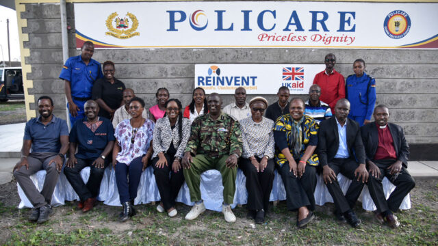 Police officers and community members gathered under a “Policare Priceless Dignity banner