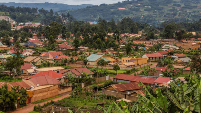 Aerial view of Kabale Uganda with colorful rooftops surrounded by mountains and trees