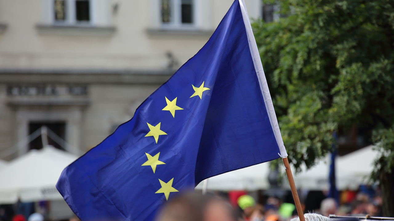 European Union flag being waved above a crowd
