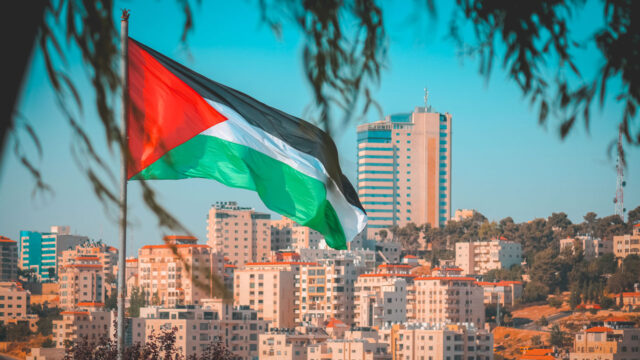 View of a city skyline with the Palestinian flag flying in the foreground