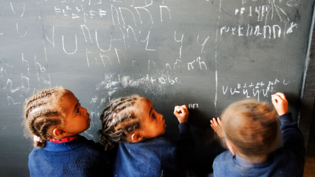Young schoolgirls writing on a chalkboard