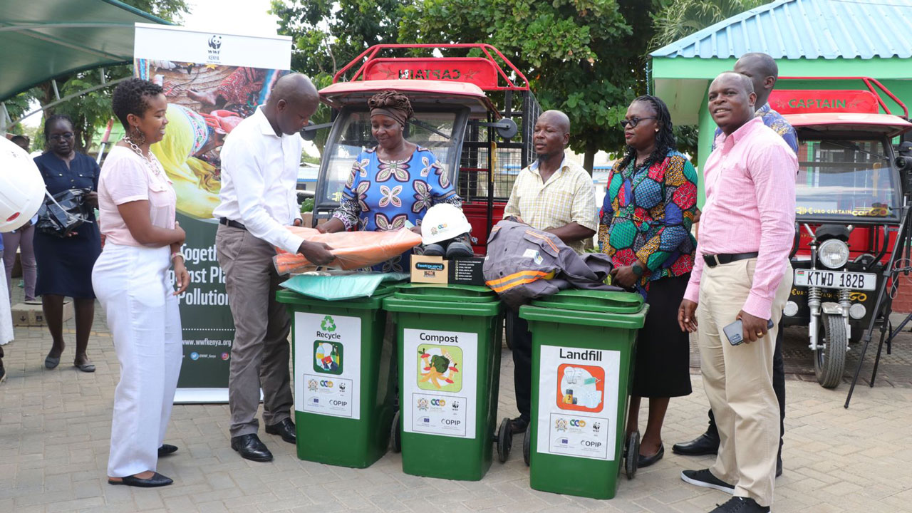 Several COPIP event attendees holding up waste disposal instruction posters