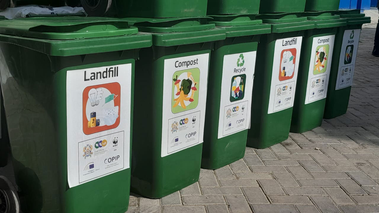 A row of waste collection bins labelled to collect different kinds of rubbish