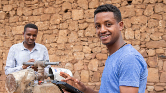 Two field scientists with tablets at a standpipe