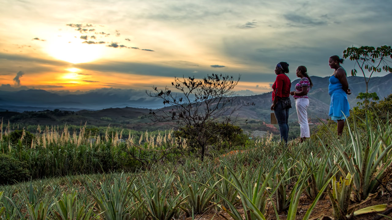 Three people watching the sun rise over the mountains