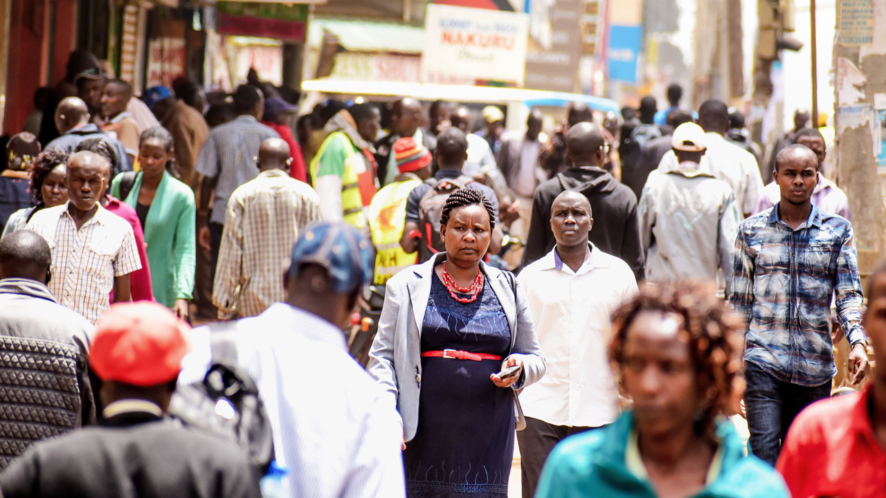 A busy street scene filled with pedestrians, showcasing a diverse crowd in an urban setting
