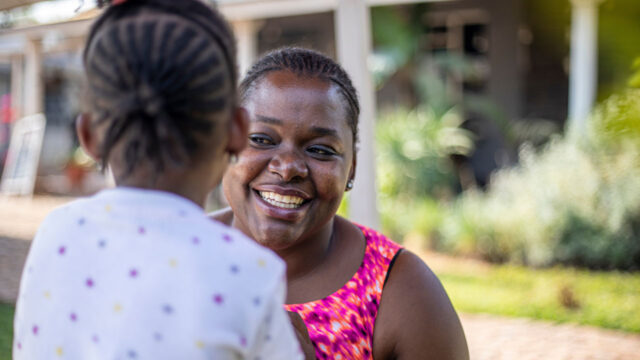 A woman smiling at a young child