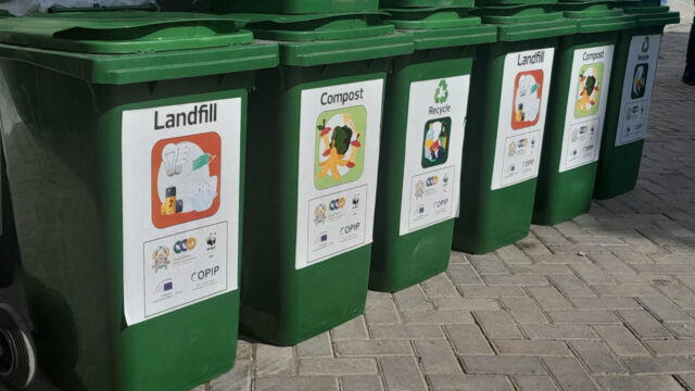 A row of waste collection bins labelled to collect different kinds of rubbish