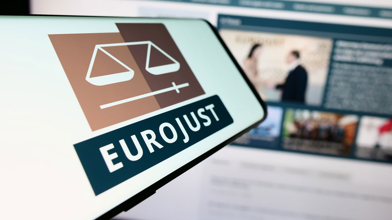 Close up of a phone screen that reads "EUROJUST"