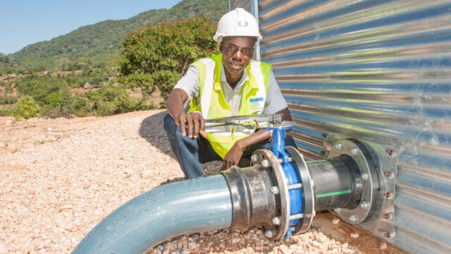 Naison Chingwe inspects a pipe at the reservoir of the Kufandada River Protection and Irrigation Scheme Project. LOCATION: Bikita District, Masvingo Province, Zimbabwe.
